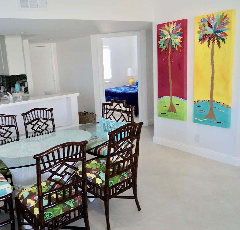 Two tall palm panels on the wall of a bright dining room