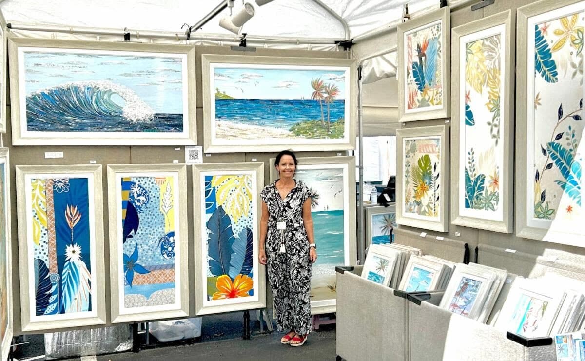 Inside the booth: walls of framed waves, palms and beach scenes, Jennifer at the back