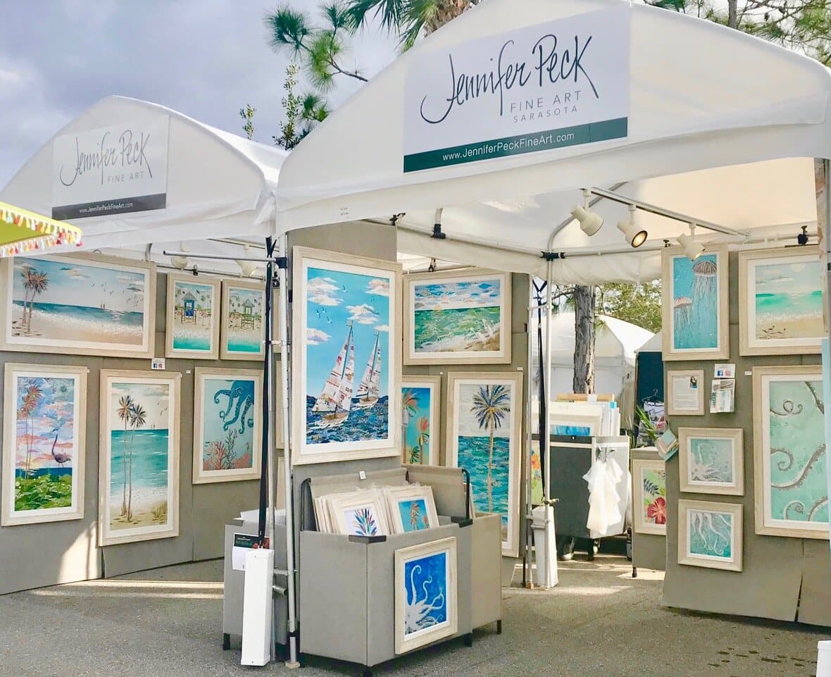 Jennifer Peck's white festival tent hung with framed coastal artwork