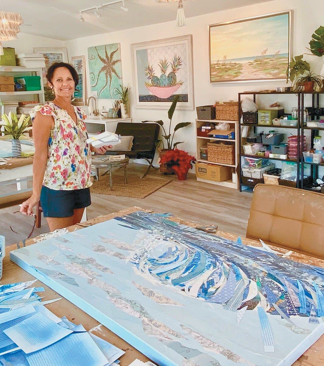 Jennifer in her studio with a large wave collage in progress on the worktable