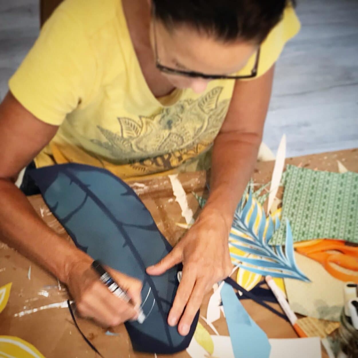 Jennifer marking vein lines on a navy paper leaf