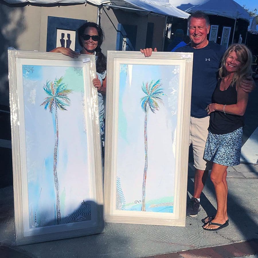 Three collectors at the booth with a pair of tall palm panels