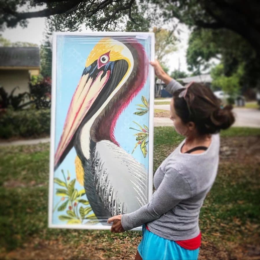 A collector carrying a tall framed pelican piece