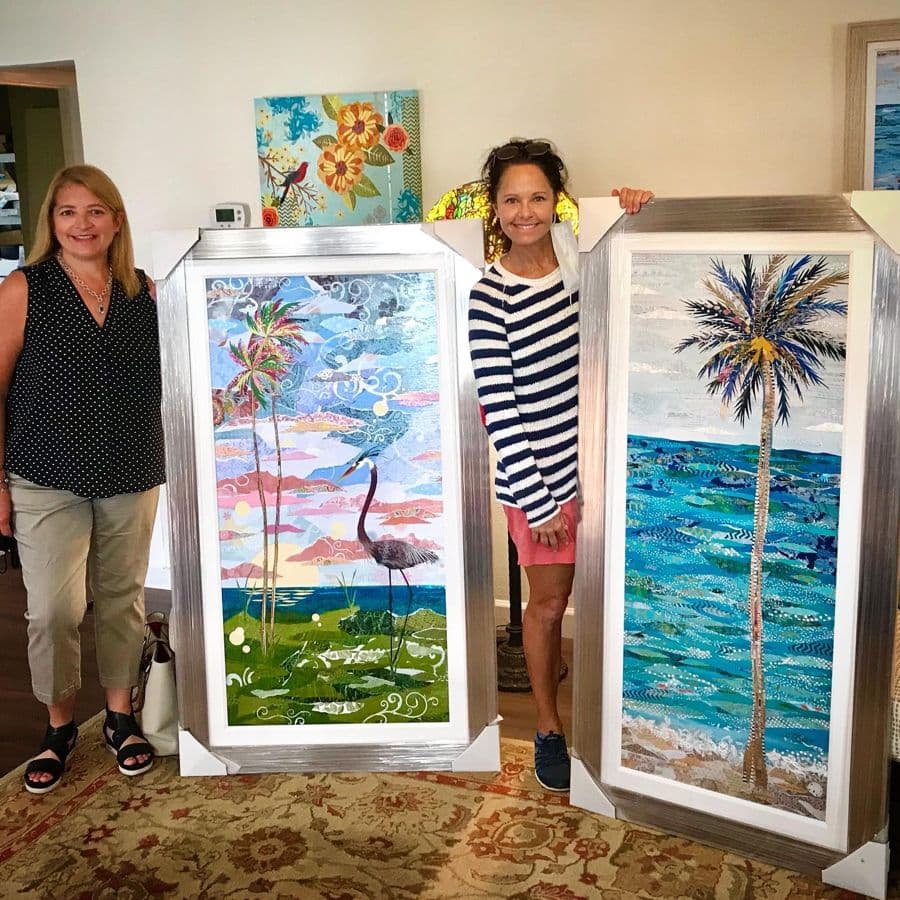 Two collectors with a pair of framed palm panels in a gallery