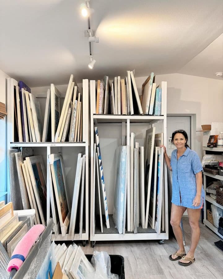 Jennifer in the studio, finished pieces racked behind her